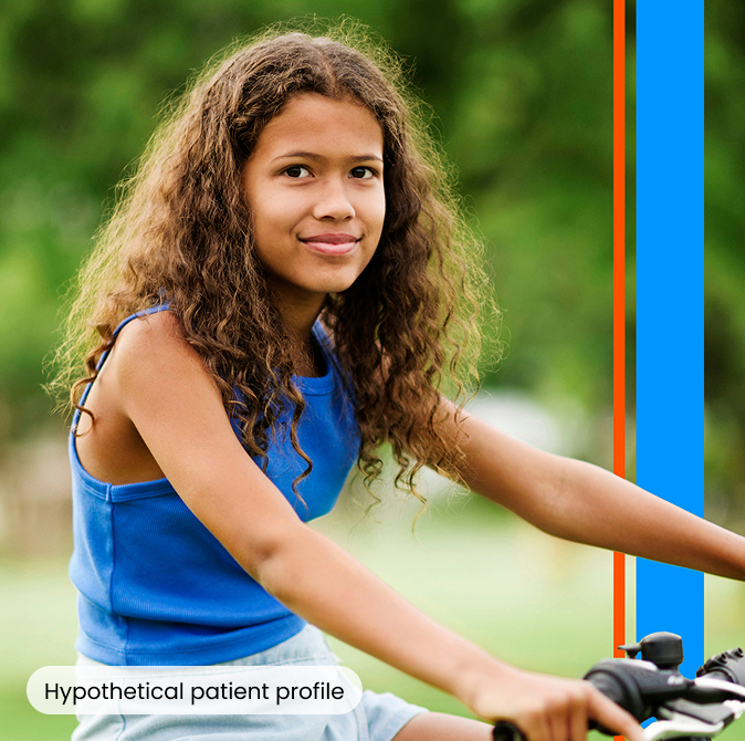A young girl riding her bike and smiling