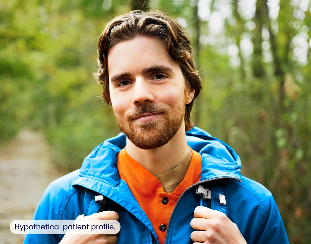 A man hiking outdoors and smiling